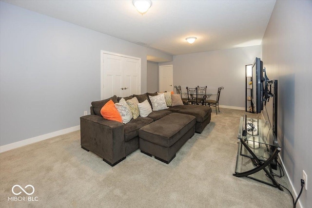 living area featuring light carpet and baseboards
