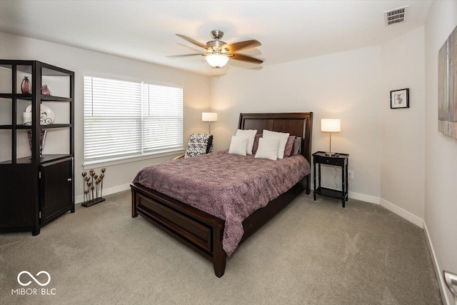 bedroom with light colored carpet, baseboards, and a ceiling fan