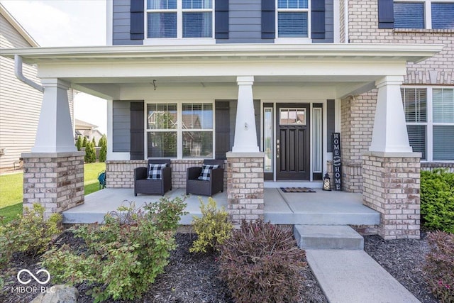 doorway to property with covered porch and brick siding