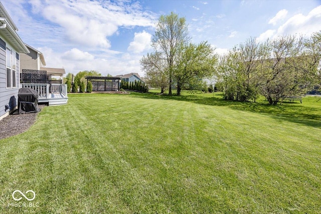 view of grassy yard with a deck