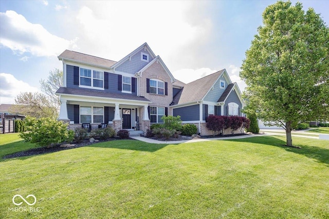 craftsman-style house with a front yard, a porch, and stone siding
