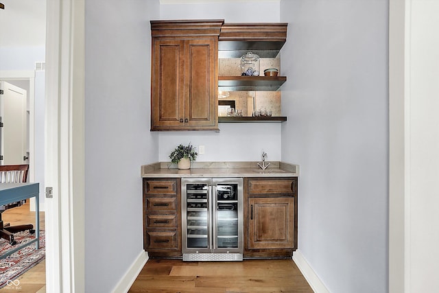 5120 Melbourne Pl, Zionsville, IN 46077 - indoor dry bar with wine cooler, baseboards, and wood finished floors