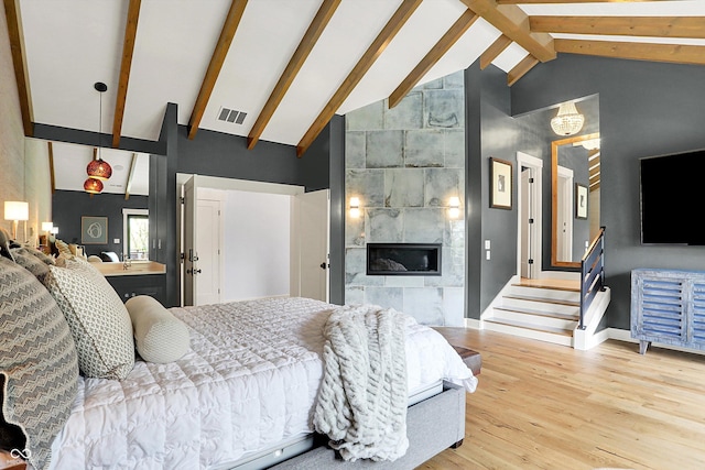5120 Melbourne Pl, Zionsville, IN 46077 - bedroom with high vaulted ceiling, wood finished floors, baseboards, a tiled fireplace, and beam ceiling