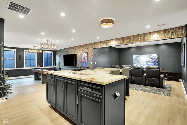5120 Melbourne Pl, Zionsville, IN 46077 - kitchen with dark cabinets, light wood-style flooring, open floor plan, a center island, and recessed lighting
