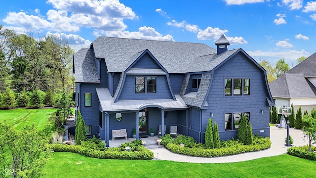 5120 Melbourne Pl, Zionsville, IN 46077 - view of front facade with covered porch, a front yard, a standing seam roof, roof with shingles, and metal roof
