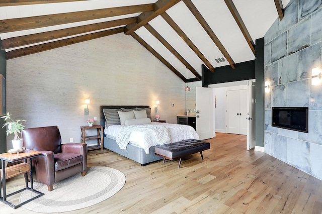 5120 Melbourne Pl, Zionsville, IN 46077 - bedroom featuring high vaulted ceiling, light wood-style flooring, a fireplace, and beam ceiling