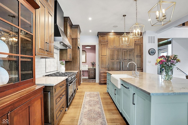 5120 Melbourne Pl, Zionsville, IN 46077 - kitchen with a sink, high end stove, a chandelier, light wood-style flooring, and backsplash