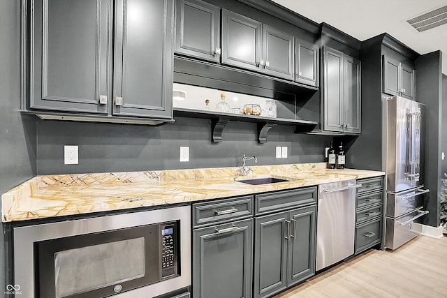 5120 Melbourne Pl, Zionsville, IN 46077 - kitchen with stainless steel appliances, a sink, light wood finished floors, and open shelves