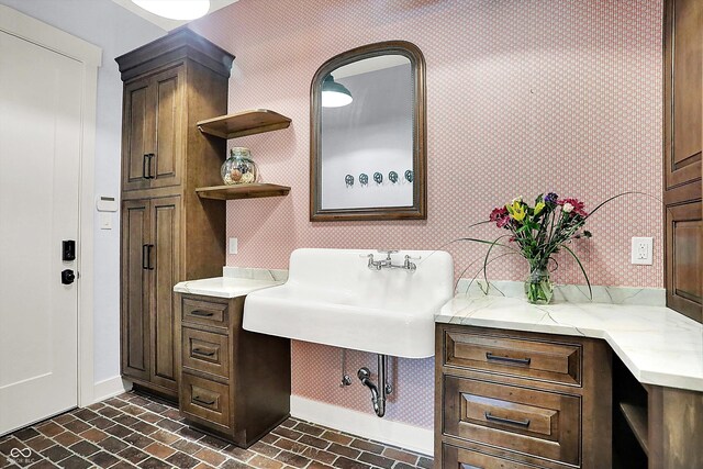 5120 Melbourne Pl, Zionsville, IN 46077 - bathroom with baseboards, wallpapered walls, brick patterned floors, and a sink