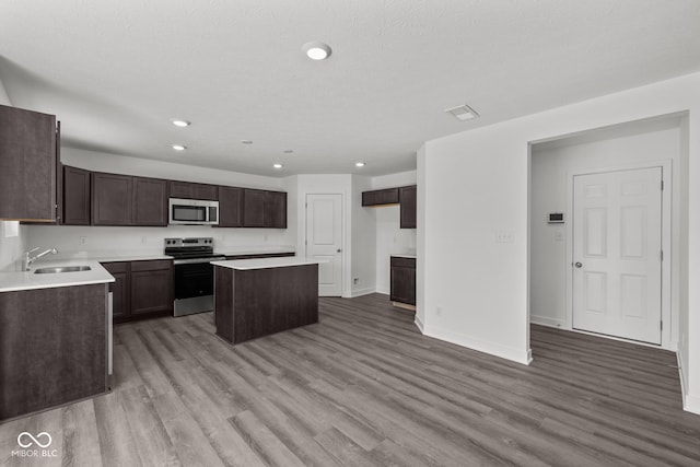 3913 Highcrest Rd, Indianapolis, IN 46239 - kitchen featuring stainless steel appliances, a sink, a center island, light wood-style floors, and recessed lighting