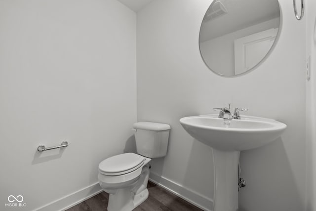 3913 Highcrest Rd, Indianapolis, IN 46239 - half bath featuring baseboards, toilet, and wood finished floors