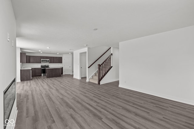 3913 Highcrest Rd, Indianapolis, IN 46239 - unfurnished living room featuring wood finished floors, stairs, recessed lighting, and baseboards