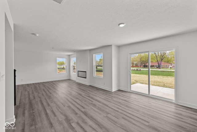 3913 Highcrest Rd, Indianapolis, IN 46239 - unfurnished living room with a textured ceiling, wood finished floors, healthy amount of natural light, and baseboards