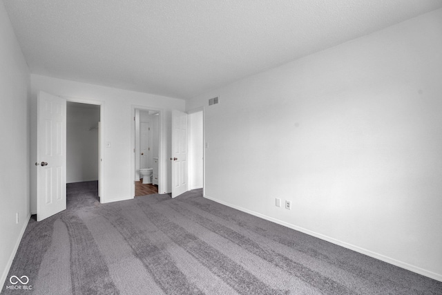 1847 Crystal Bay E Dr, Plainfield, IN 46168 - unfurnished bedroom with a spacious closet, visible vents, dark colored carpet, and baseboards