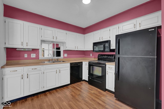 1847 Crystal Bay E Dr, Plainfield, IN 46168 - kitchen featuring light countertops, wood finished floors, white cabinets, black appliances, and a sink