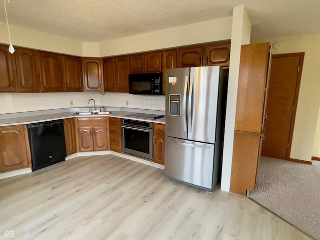 1 Vaught Rd, Hartford City, IN 47348 - kitchen featuring light wood-style flooring, a sink, brown cabinetry, light countertops, and black appliances