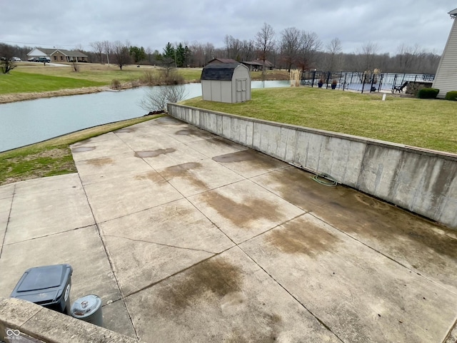 1 Vaught Rd, Hartford City, IN 47348 - view of patio featuring a storage shed, an outbuilding, a water view, and fence