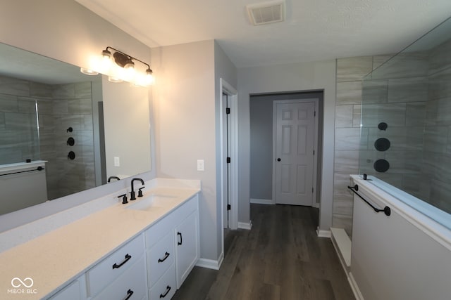 10609 Banyan Wood Ct, Indianapolis, IN 46239 - bathroom featuring wood finished floors, a walk in shower, baseboards, and vanity