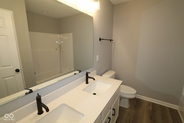 10609 Banyan Wood Ct, Indianapolis, IN 46239 - bathroom with toilet, wood finished floors, double vanity, and baseboards