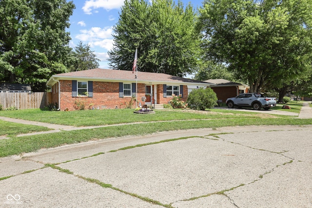 ranch-style house featuring driveway, a front lawn, fence, a garage, and brick siding