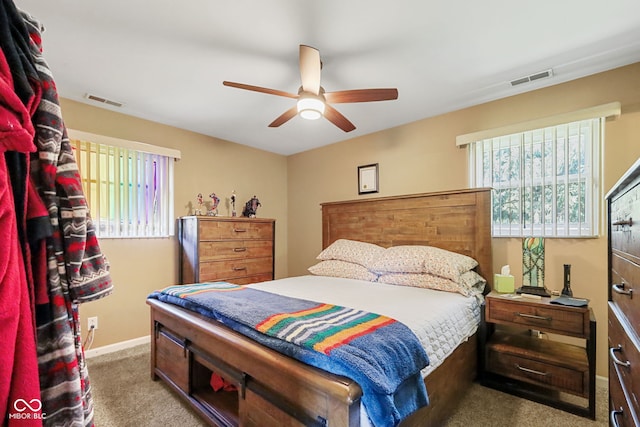 carpeted bedroom featuring multiple windows, baseboards, and visible vents