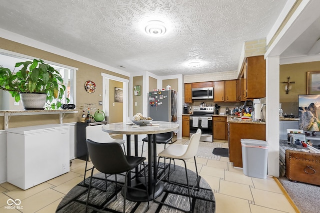 dining space featuring light tile patterned floors and a textured ceiling