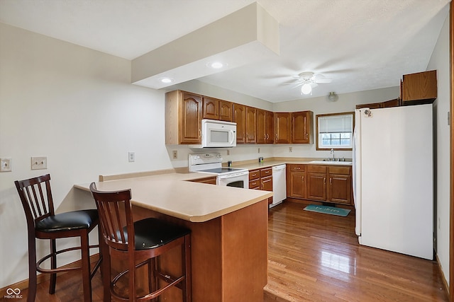 5371 Lue Ann Ln, Mooresville, IN 46158 - kitchen with a peninsula, white appliances, ceiling fan, a sink, and dark wood-style floors