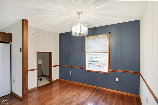 5371 Lue Ann Ln, Mooresville, IN 46158 - spare room with visible vents, baseboards, a chandelier, and wood finished floors