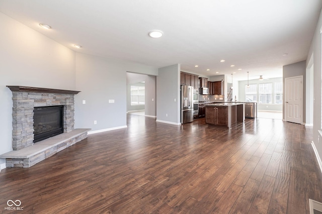 2314 Angelina Way, Greenwood, IN 46143 - unfurnished living room featuring dark wood-style flooring, visible vents, baseboards, recessed lighting, and a stone fireplace