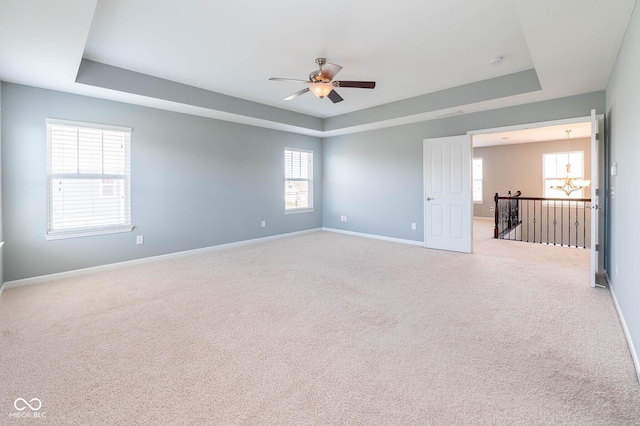 2314 Angelina Way, Greenwood, IN 46143 - empty room featuring baseboards, light carpet, ceiling fan with notable chandelier, and a raised ceiling