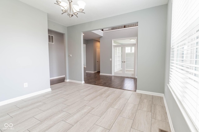 2314 Angelina Way, Greenwood, IN 46143 - unfurnished room featuring an inviting chandelier, french doors, baseboards, visible vents, and wood tiled floor