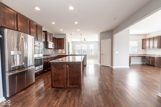 2314 Angelina Way, Greenwood, IN 46143 - kitchen featuring dark brown cabinetry, appliances with stainless steel finishes, light stone counters, and dark wood-type flooring