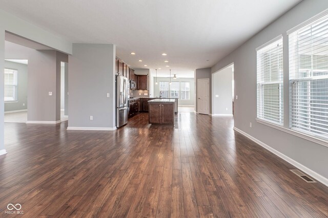 2314 Angelina Way, Greenwood, IN 46143 - unfurnished living room featuring recessed lighting, baseboards, dark wood finished floors, a sink, and visible vents