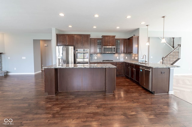 2314 Angelina Way, Greenwood, IN 46143 - kitchen with a peninsula, stainless steel appliances, dark wood-type flooring, a sink, and a center island