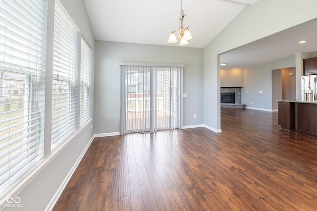 2314 Angelina Way, Greenwood, IN 46143 - empty room with dark wood finished floors, baseboards, lofted ceiling, and an inviting chandelier