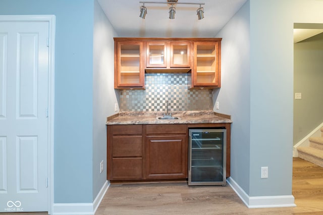 2314 Angelina Way, Greenwood, IN 46143 - bar with light wood-style floors, wine cooler, stairs, and decorative backsplash