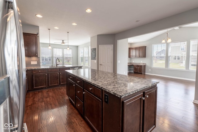 2314 Angelina Way, Greenwood, IN 46143 - kitchen with decorative light fixtures, dark stone countertops, dark wood finished floors, a kitchen island, and freestanding refrigerator