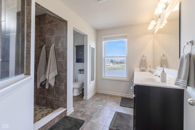 12959 Balfour Rd, Fishers, IN 46037 - full bath with vanity, toilet, a tile shower, a chandelier, and baseboards