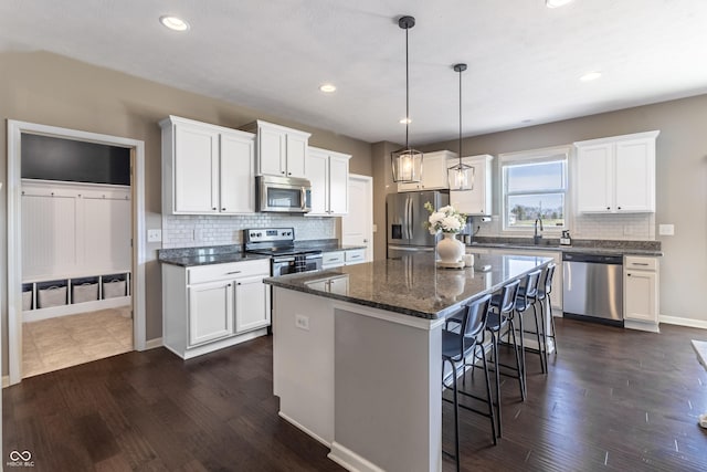 12959 Balfour Rd, Fishers, IN 46037 - kitchen featuring stainless steel appliances, a kitchen breakfast bar, a sink, decorative backsplash, and a kitchen island