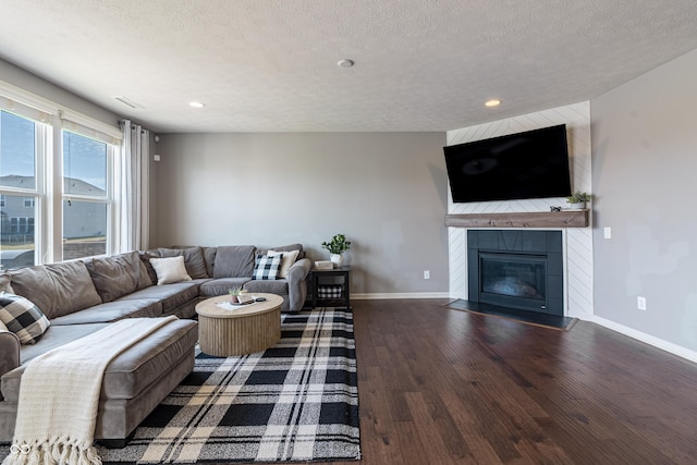 12959 Balfour Rd, Fishers, IN 46037 - living room with baseboards, wood finished floors, a tiled fireplace, recessed lighting, and a textured ceiling