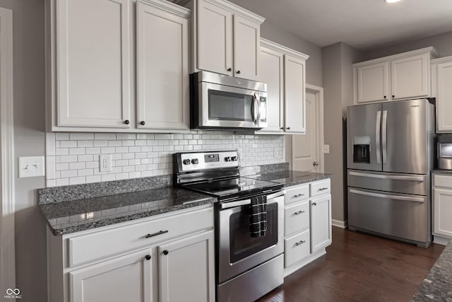 12959 Balfour Rd, Fishers, IN 46037 - kitchen with appliances with stainless steel finishes, dark wood finished floors, dark stone counters, tasteful backsplash, and white cabinetry