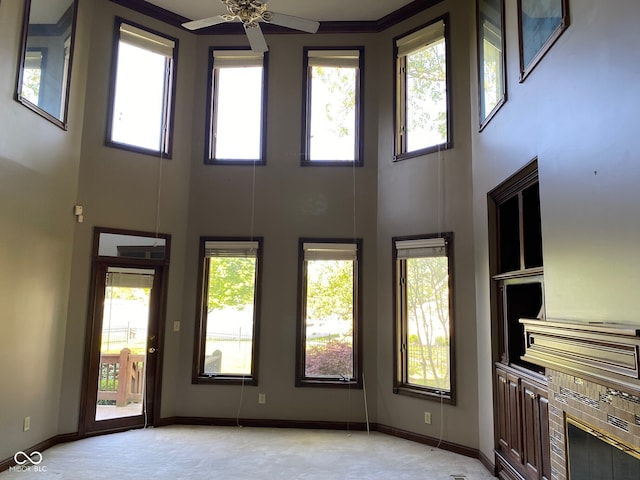 11967 Windpointe Pass, Carmel, IN 46033 - unfurnished living room with a towering ceiling, healthy amount of natural light, a ceiling fan, and baseboards