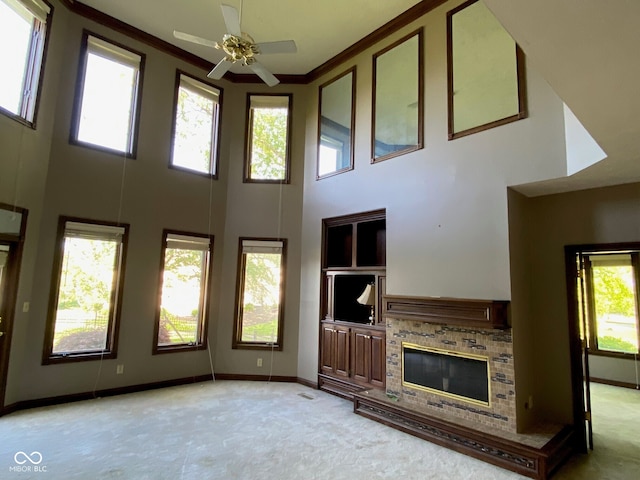 11967 Windpointe Pass, Carmel, IN 46033 - unfurnished living room featuring a high ceiling, ceiling fan, a brick fireplace, crown molding, and light carpet