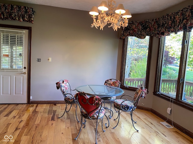 11967 Windpointe Pass, Carmel, IN 46033 - dining room with a chandelier, light wood-type flooring, and baseboards