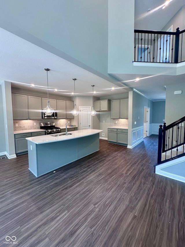 6887 Oakdale Ln, Avon, IN 46123 - kitchen with stainless steel appliances, dark wood-type flooring, gray cabinets, an island with sink, and light countertops