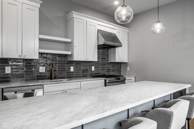 1665 N College Ave, Indianapolis, IN 46202 - kitchen with a sink, wall chimney range hood, appliances with stainless steel finishes, decorative backsplash, and a breakfast bar
