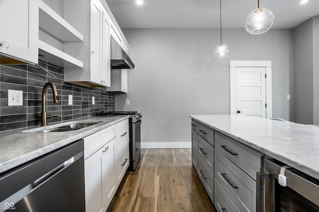 1665 N College Ave, Indianapolis, IN 46202 - kitchen featuring stainless steel dishwasher, a sink, gas range, under cabinet range hood, and decorative backsplash