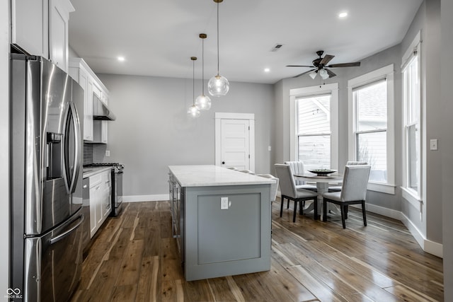 1665 N College Ave, Indianapolis, IN 46202 - kitchen featuring stainless steel appliances, a center island, baseboards, a ceiling fan, and white cabinets