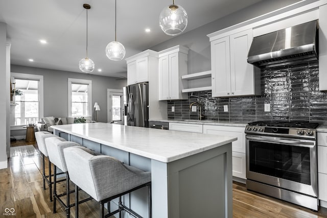 1665 N College Ave, Indianapolis, IN 46202 - kitchen featuring stainless steel appliances, wall chimney exhaust hood, a sink, open shelves, and a center island
