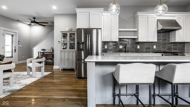 1665 N College Ave, Indianapolis, IN 46202 - kitchen featuring appliances with stainless steel finishes, exhaust hood, a ceiling fan, light countertops, and backsplash